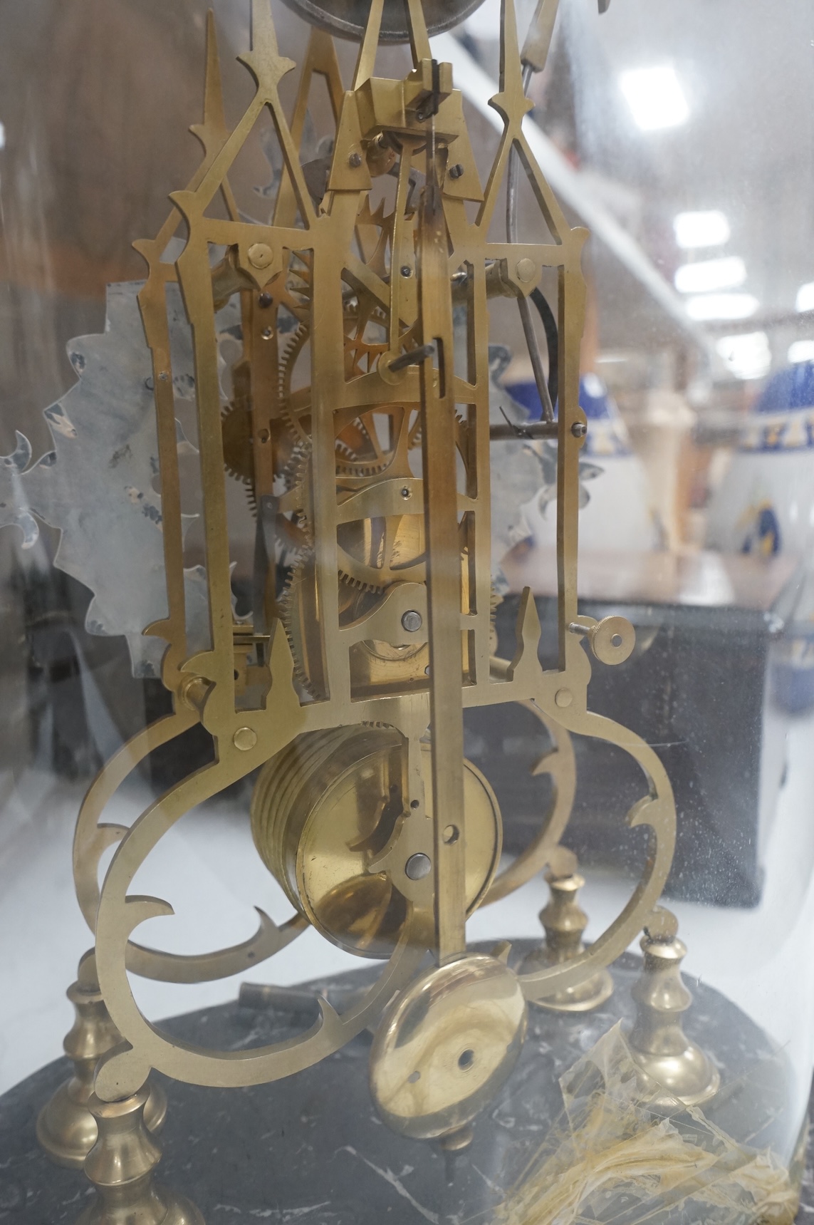 A large skeleton clock under dome, on grey marble base. 44cm high